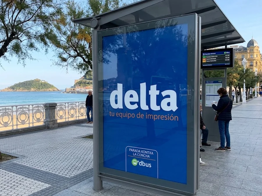 Mupi con un cartel de Delta en una parada de autobús del paseo de La Concha